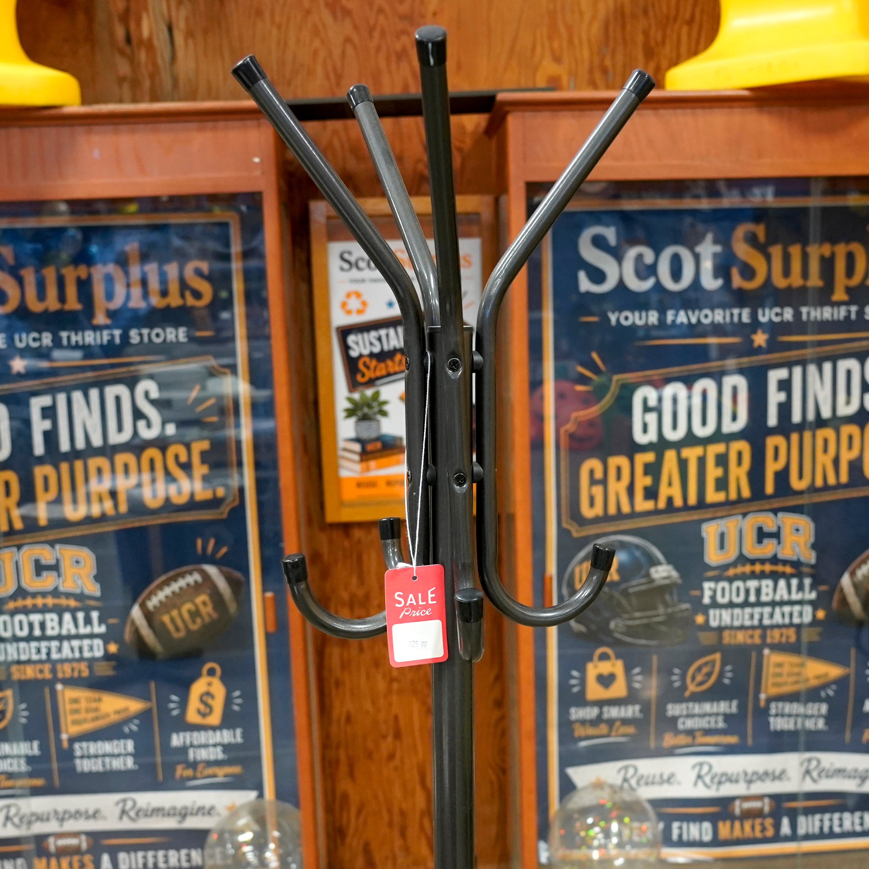 A standing black metal coat rack with 8 hooks.