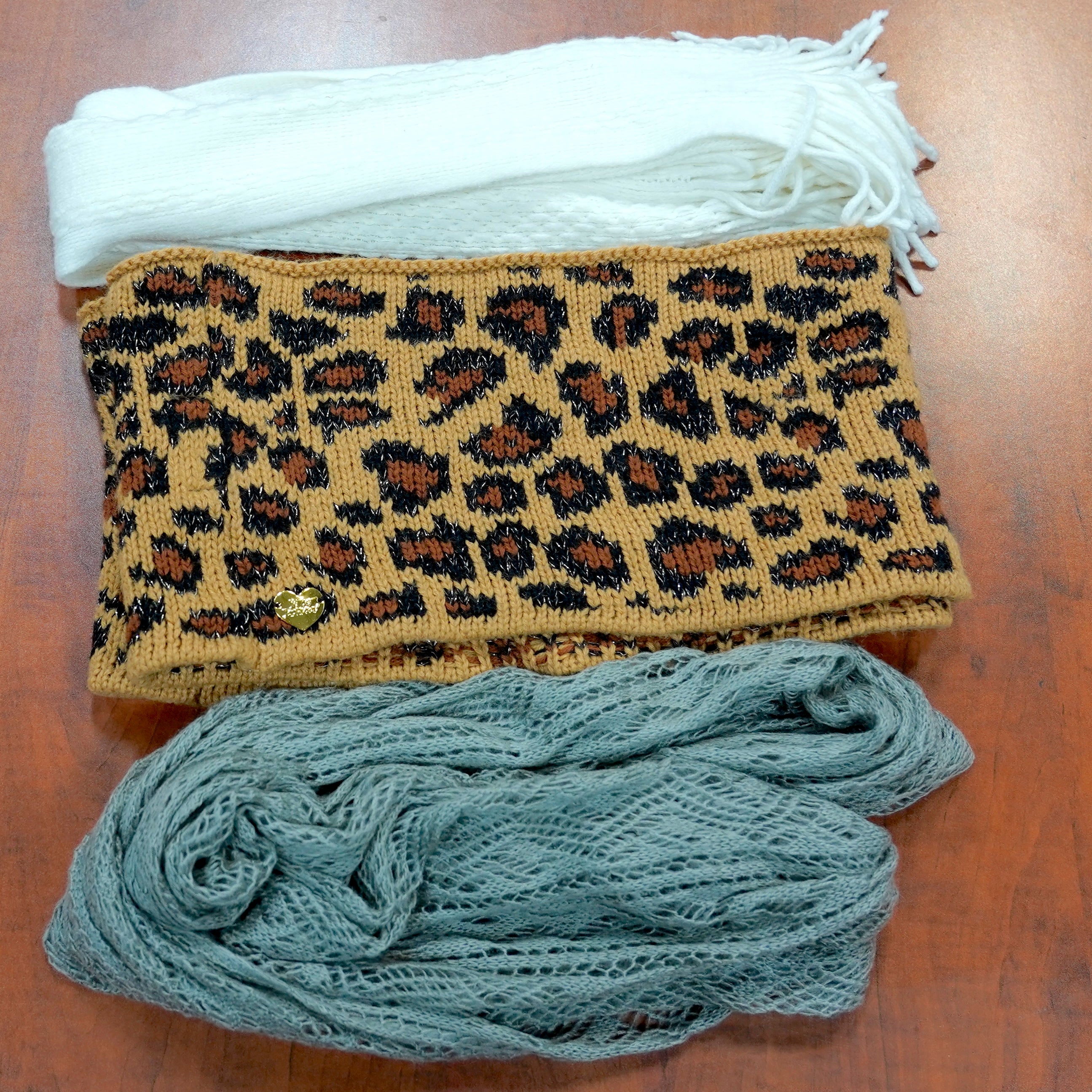 Three scarves in white, gray, and cheetah print.