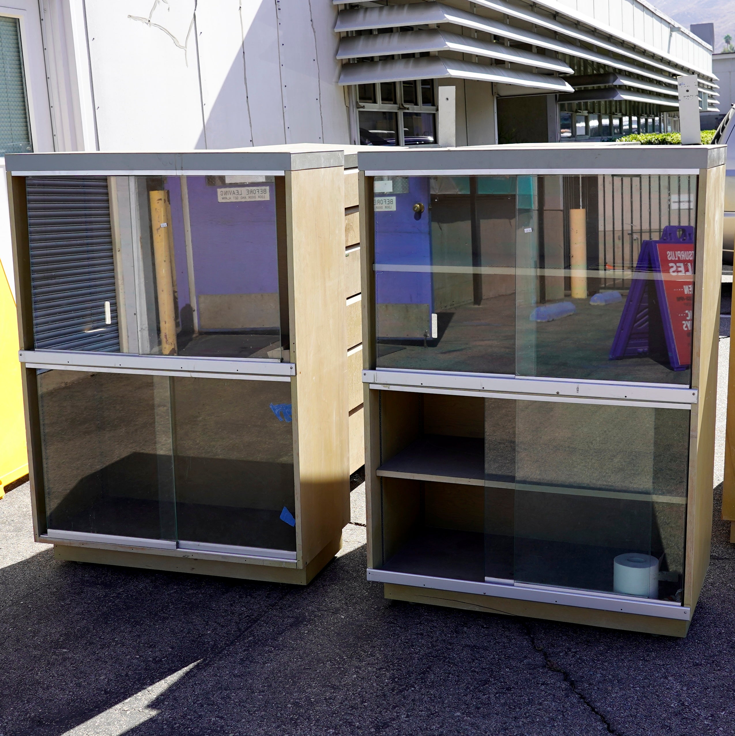 Vintage display/storage cabinets featuring light wood-grain laminate bodies and sliding glass doors.