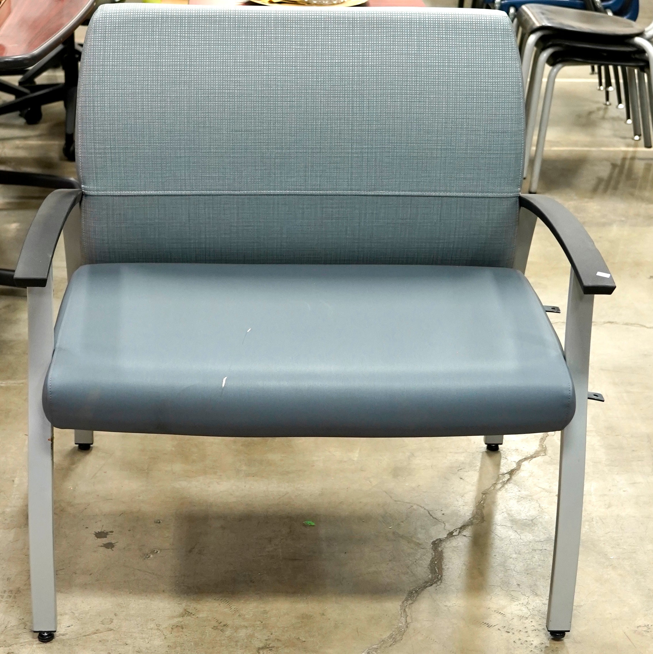 Light blue oversized vinyl guest chair with gray metal legs.