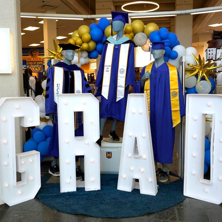 Light-up letters that spell out GRAD with blue graduation robes.