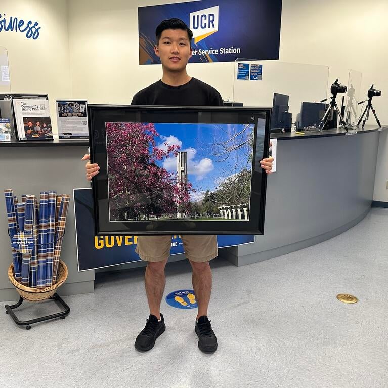 Han Li R'Card Contest Winner with framed winner.