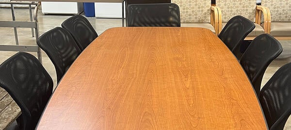 long conference table with black rolling chairs