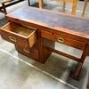 A vintage four-drawer wooden desk.
